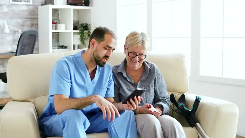 A carer helping an older woman with her phone